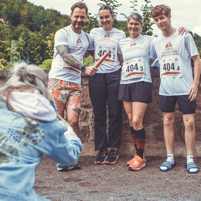 21 km Staffel-Lauf Staffelteam posiert mit Staffelstab für ein Foto beim Stolberger Schloss-Lauf.